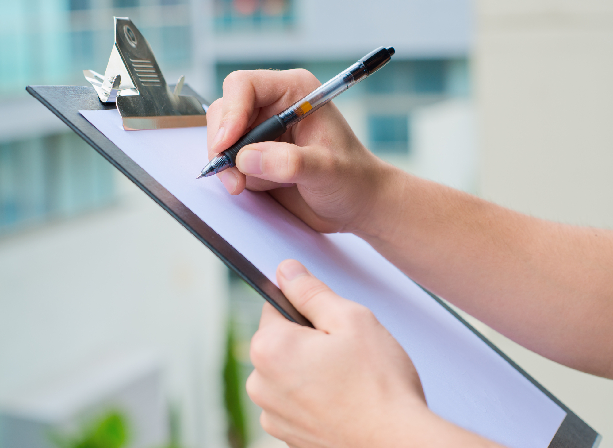 Businessman Holding A Clipboard And Writing