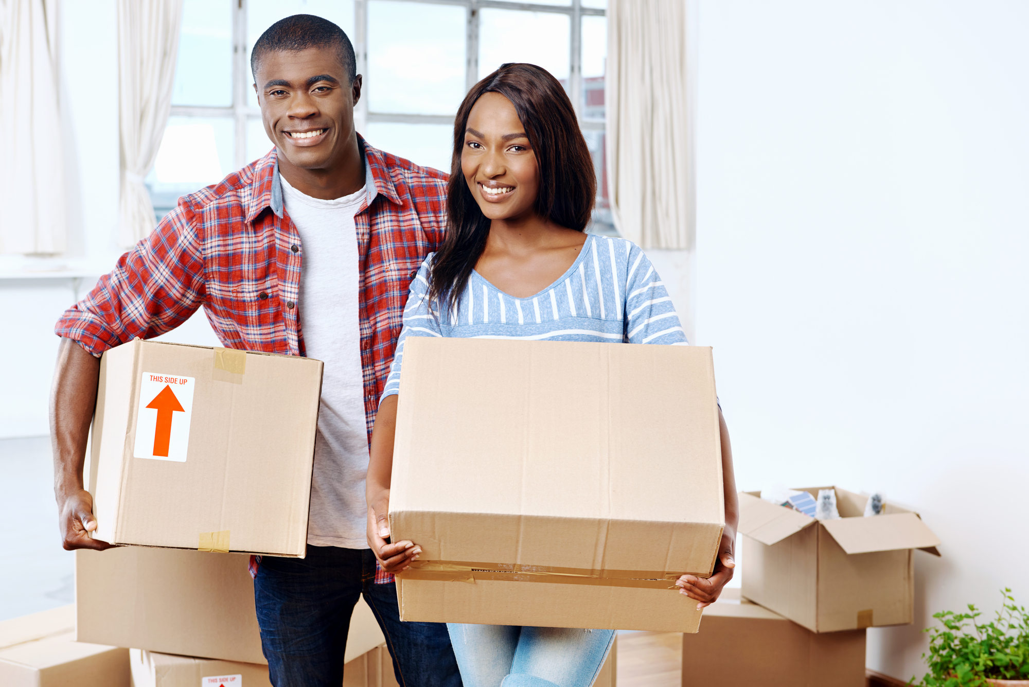 Couple moving boxes into new home